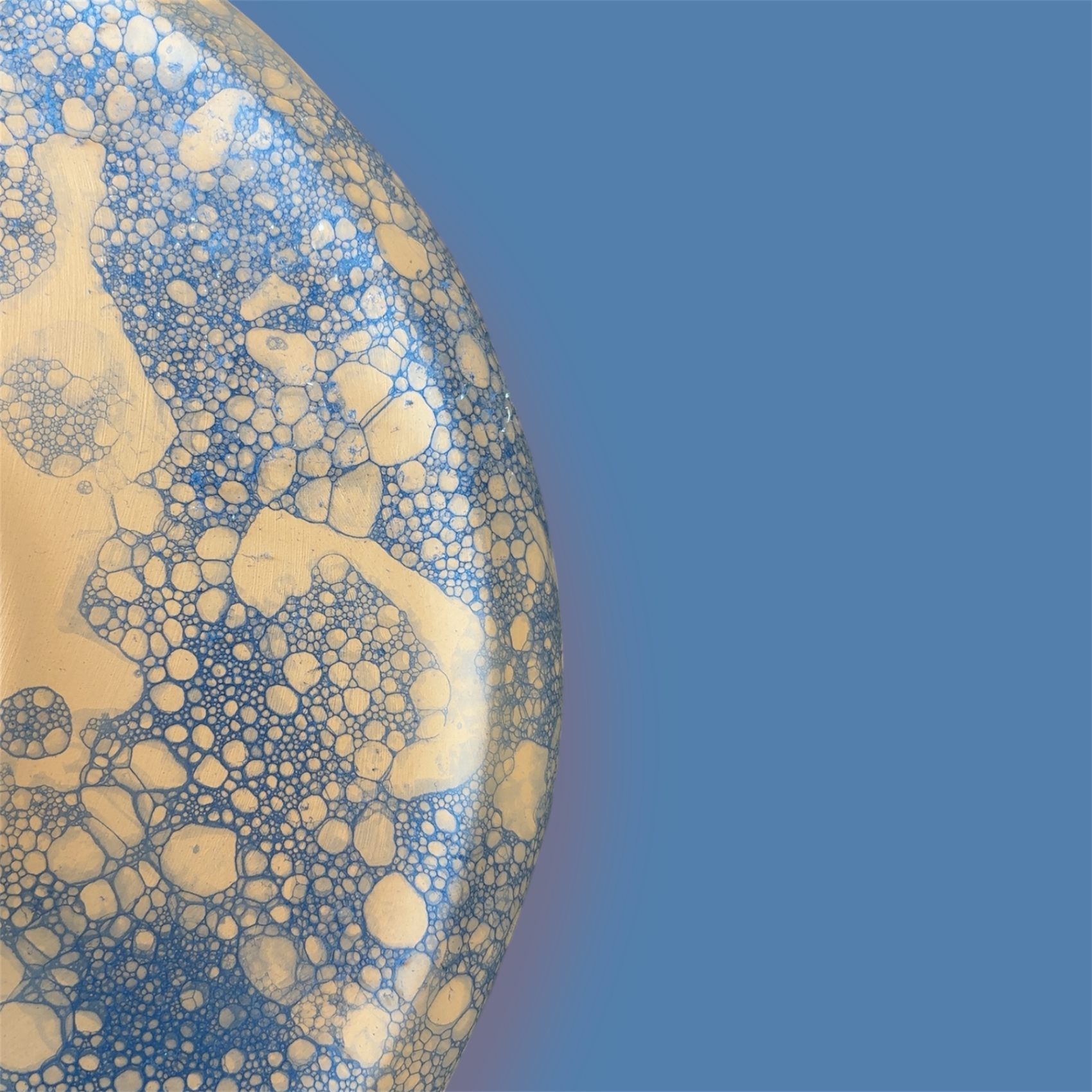 Macro detail of a crawling blue and cream glaze surface